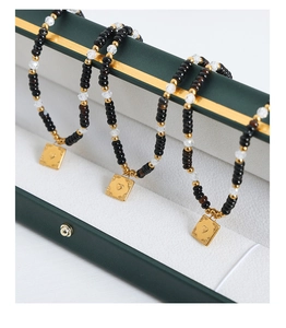 Macro shot of tiger eye beads and golden heart pendant on a luxury steel necklace