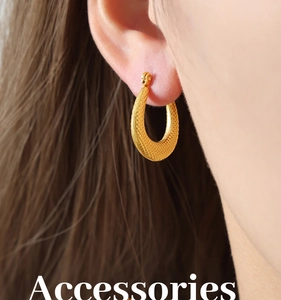 Detailed view of golden teardrop earring with textured mesh finish and vintage style