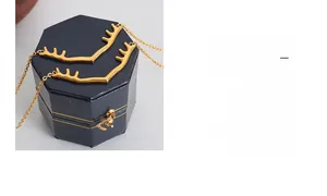Détail d'un collier pendentif bois de cerf doré présenté dans un écrin à bijoux bleu marine