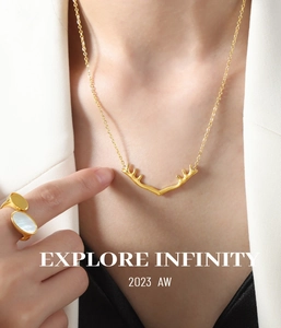 Gros plan d'un collier pendentif bois de cerf doré porté sur le cou d'un mannequin