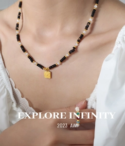 Detail of beaded tiger eye necklace with heart pendant and matching rings on a model