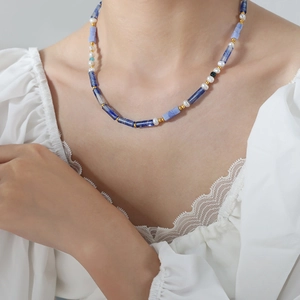Collier en sodalite bleue naturelle et perles porté par un mannequin en dentelle