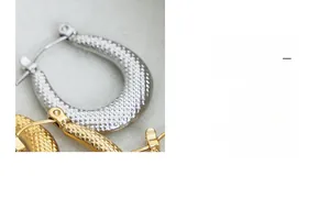 Detail view of U-shaped hoop earrings with unique hammered texture in gold and silver finish
