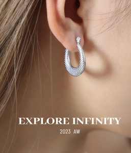 Detail of silver U-shaped hoop earrings with diamond-cut textured finish on female model