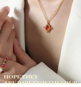 Gros plan détaillé d'un collier pendentif croix vintage doré orné d'une agate rouge ovale