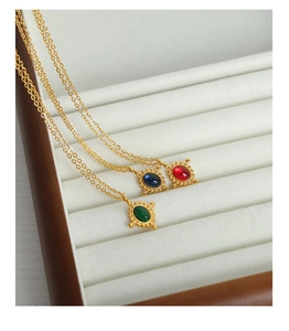 Détail du collier en or vintage avec pierres d'agate ovales rouges, bleues et vertes