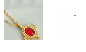 Gros plan d'un pendentif en agate rouge ovale avec perles dorées sur collier vintage chic