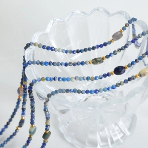 Bohemian faceted natural stone necklace with blue stones and gold beads on glass