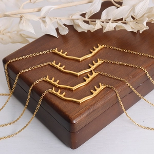 Collier avec pendentif bois de cerf plaqué or 18k sur un coffret à bijoux en bois élégant