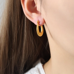 U-shaped gold striped hoop earrings featuring a minimalist geometric baroque design