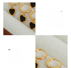 Gros plan de boucles d'oreilles cœur vintage en or et acrylique noir sur écrin