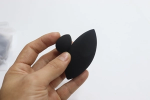 Detail of two black makeup sponges including a mini waterdrop and olive cut sponge