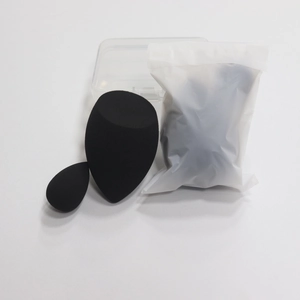 Close-up of dual-size black makeup sponges with clear storage box and frosted bag