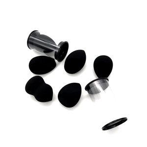Detailed set of black makeup sponges in teardrop and cut shapes with clear storage tubes
