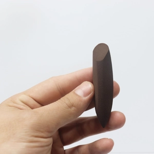Dark brown makeup sponge with slanted tip for precision contouring held by hand