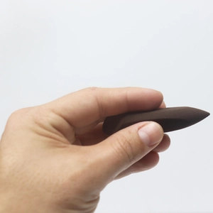 Close-up of a dark brown precision makeup sponge for undereye and nose area blending