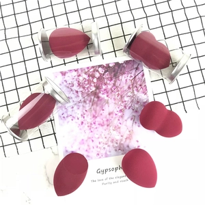 Deep burgundy makeup sponge set with teardrop and slanted designs in storage tubes