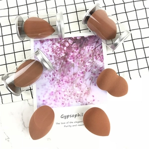 Latte brown makeup sponge set with teardrop shapes and storage tubes on marble