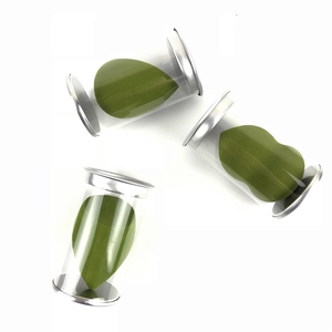 Three olive green makeup sponges in transparent cylindrical containers with silver lids