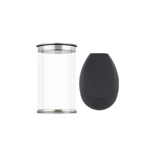 Detail van de zwarte make-up spons en de transparante cilindrische opbergbak voor cosmetica