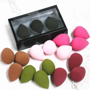 Flat lay of colorful teardrop blending sponges with elegant black window display box