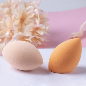 Close-up of pink and orange teardrop makeup sponges with dense texture and soft surface