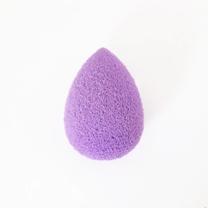 Detail eines lila Make-up-Schwamms in Tropfenform mit sichtbarer Porenstruktur