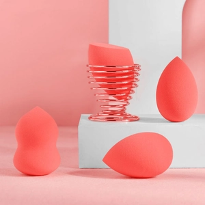 Set de esponjas de maquillaje rosa coral con varias formas y soporte de metal cobre