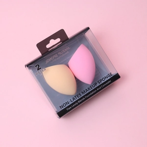 Pink and nude makeup sponges set in transparent packaging box on pink background