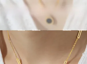 Detail view of 18K gold paperclip chain necklace with Roman numeral acrylic pendant