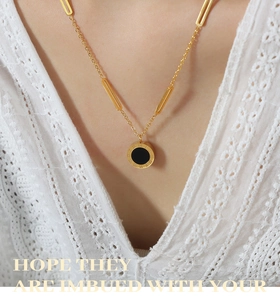 Close-up of a vintage Roman numeral medallion necklace with 18k gold plating and shell inlay