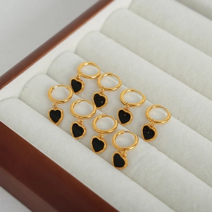 Élégantes boucles d'oreilles cœur dorées avec pendentif acrylique noir sur velours