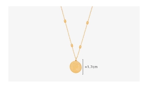 Detail view of a 1.7cm vintage gold-plated relief coin pendant on a beaded chain