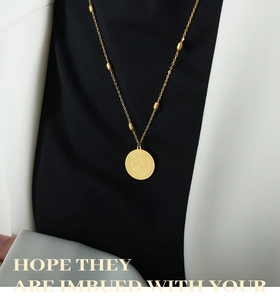Close-up of vintage gold coin necklace with relief portrait and olive-shaped beads