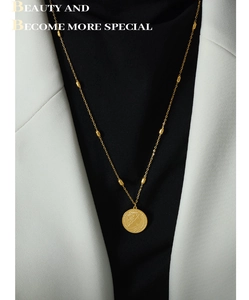 Detailed view of vintage gold coin necklace with portrait pendant and beaded chain detail