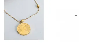 Close-up of gold coin pendant with Elizabeth II embossed relief on titanium steel chain