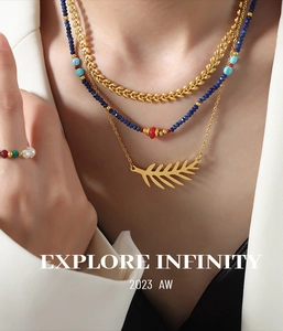 Detalle de conjunto de collares a capas con colgante de hoja y cuentas azules en modelo
