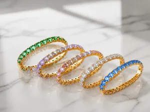 Nahaufnahme von vergoldeten Titanarmbändern mit bunten Zirkonia-Steinen in verschiedenen Farben