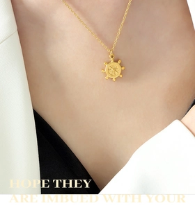 Détail d'un collier avec pendentif gouvernail nautique plaqué or 18 carats sur un mannequin