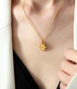 Vue détaillée du collier pendentif gouvernail rétro français en or 18k mat sur modèle