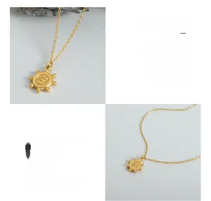 Détail macro du collier pendentif gouvernail en acier titane chirurgical plaqué or 18 carats