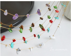 Detail of multi-layered gold necklace with colorful irregular natural stones and turquoise