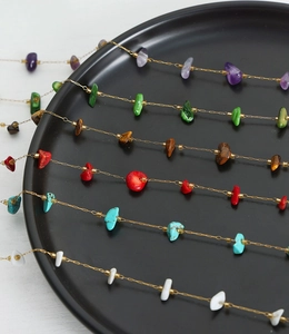 Detail of colorful natural stone pendants on gold plated titanium steel necklaces
