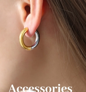 Close-up of two-tone gold and silver chunky hoop earrings on a model's ear