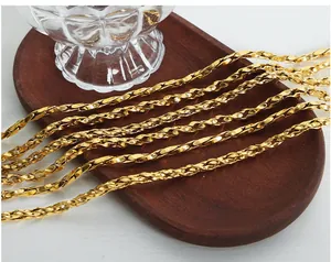 Detailed view of a polished gold twisted chain displayed on a dark wooden tray
