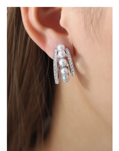 Détail des boucles d'oreilles multicouches en acier titane avec perles de coquillage