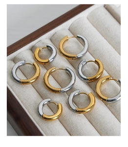 Detail of two-tone gold and silver geometric hoop earrings in four various sizes