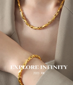Detailed view of twisted gold link chain necklace and bracelet on model neck and wrist
