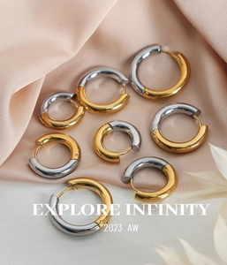 Close-up of geometric gold and silver mixed metal hoop earrings on champagne silk