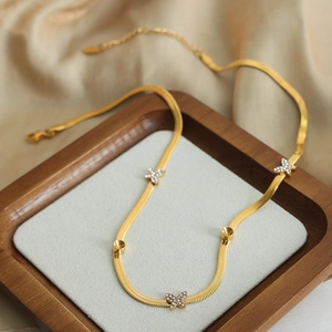 Collier maille serpent en titane doré avec trois breloques papillons serties de cristaux